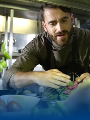 A chef wearing a BP® work shirt stands in the kitchen.