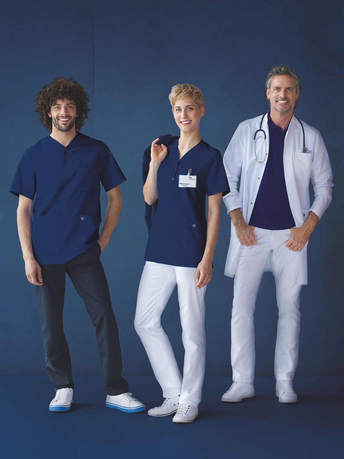 Two men and a woman pose in outfits for a hospital team.