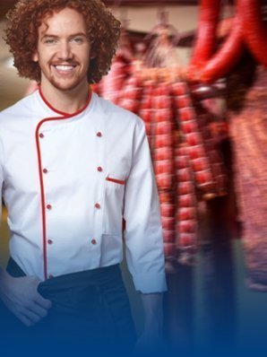 Butcher wearing a butcher's jacket. Meat products can be seen in the background.