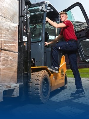 A logistician in the Rheinenergiestadion climbs onto a forklift truck in BP® work clothing.